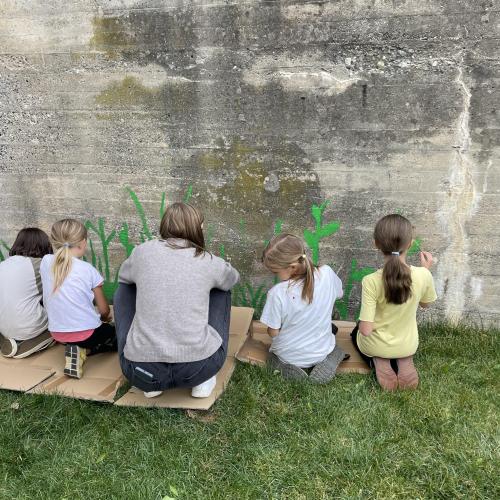 Kinder beim Bemalen der Betonmauer 